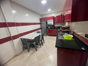 a kitchen with a table and red and white stripes at اقامة السعادة in Monte ʼArrouit