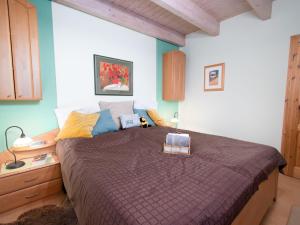 - une chambre avec un grand lit et une couette brune dans l'établissement Holiday Home Bärbel by Interhome, à Norden