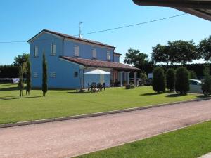 uma casa azul com uma mesa e cadeiras num relvado em Insolent Inn em Gatteo a Mare