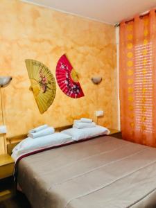 1 dormitorio con 1 cama y 2 sombrillas en la pared en Affittacamere Selene, en San Remo