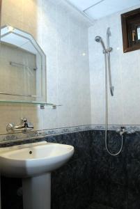 a bathroom with a sink and a shower with a mirror at Hotel Bolyarka in Melnik