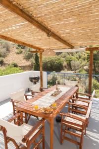 a wooden table and chairs on a deck with a wooden ceiling at AGIAZI Poros Summer House in Galatas