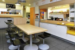 a kitchen area with a table and chairs at hotelF1 Périgueux in Boulazac