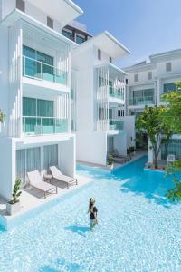 北芭堤雅的住宿－Prima Hotel Pattaya，建筑物前游泳池中的女人