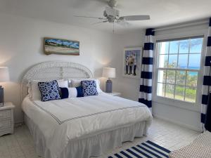 a bedroom with a bed with blue and white pillows at Treasured villa in Savannah Sound