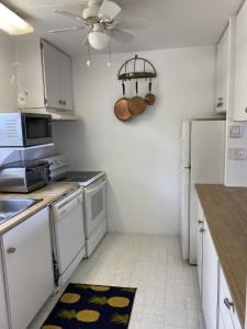 a kitchen with white appliances and a ceiling fan at Treasured villa in Savannah Sound