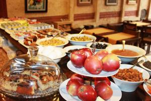a buffet of food with apples on plates on a table at Hotel SultanHill in Istanbul