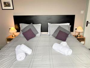 a bed with white towels and pillows on it at Sunray Apartments in Barmouth