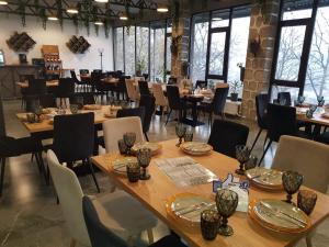 una sala da pranzo con tavoli e sedie in legno di Popock Goris a Goris