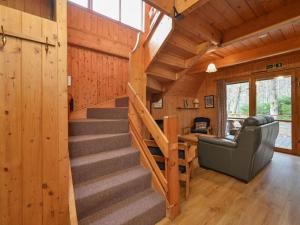 a staircase in a cabin with a couch and a table at Chalet Birchwood Cottage by Interhome in Inverness