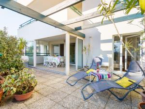 un patio con sedie e tavolo e una sala da pranzo di Apartment Les Jardins Victoria-1 by Interhome a Biarritz
