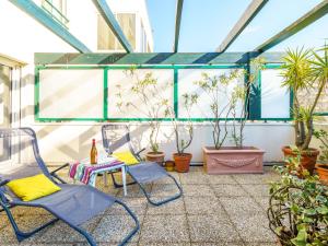 un patio con sedie e piante in vaso di Apartment Les Jardins Victoria-1 by Interhome a Biarritz