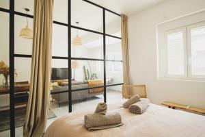 a bedroom with a large bed with towels on it at Ocean View Ha Apartment in Cádiz