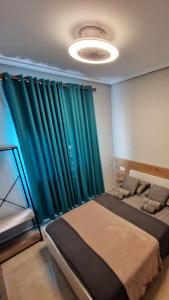a bedroom with two beds with green curtains at Carthago Suites (Centro - Casco histórico) in Cartagena