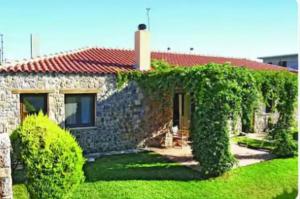 a stone house with ivy growing around it at Villa Agali. in Agia Anna