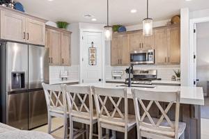 a kitchen with a bar with chairs and a refrigerator at Escondido Cove in Washington