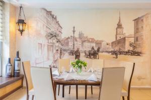 a dining room with a painting on the wall at Poleczki Residence Apartments in Warsaw