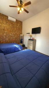 sypialnia z niebieskim łóżkiem i wentylatorem sufitowym w obiekcie La casita de Carmen con terraza w mieście Cuatrociénegas de Carranza