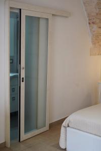 una camera da letto con porta a vetri che conduce a un letto di CASA LARI a Martina Franca