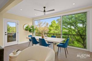 uma sala de jantar com mesa e cadeiras e uma grande janela em Stunning Two Living Rooms and 3-Room Primary Suite em Austin