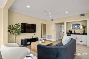 uma sala de estar com duas cadeiras azuis e uma televisão em Stunning Two Living Rooms and 3-Room Primary Suite em Austin