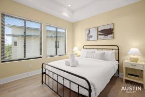 um quarto com uma cama grande e almofadas brancas em Stunning Two Living Rooms and 3-Room Primary Suite em Austin