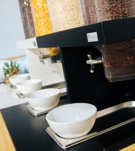 a row of white bowls sitting on a counter at Twenty Business Flats Villejuif Croizat in Villejuif