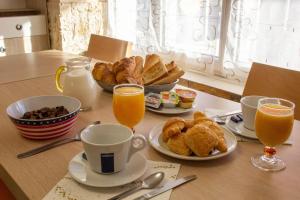 einen Tisch mit einem Frühstück mit Kaffee, Gebäck und Orangensaft in der Unterkunft Hotel du Commerce in Pontacq