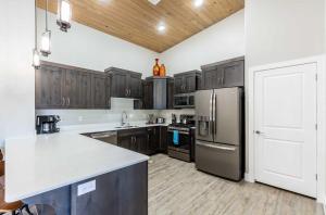 a kitchen with wooden cabinets and a stainless steel refrigerator at The Penthouse S402 condo in St. George