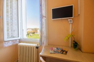 un soggiorno con TV e finestra di Hotel du Commerce a Pontacq