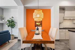 a dining room with a table with chairs and an orange wall at Best Day Ever townhouse in Washington