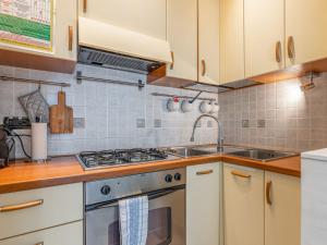 una cucina con armadi bianchi e piano cottura di Apartment Casa Lory by Interhome a Toirano