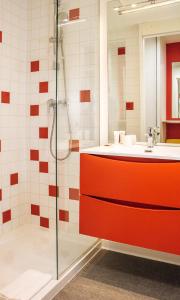 La salle de bains est pourvue d'une armoire rouge et d'une douche. dans l'établissement Twenty Business Flats Villejuif Croizat, à Villejuif
