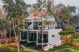 une maison entourée d'une clôture blanche dans l'établissement VeeVaree Riverkwai Resort, à Ban Kaeng Raboet