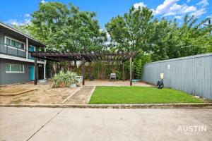 a backyard with a wooden pergola and grass at Remodeled Apt w Gated Community and In-Unit Laundry in Austin