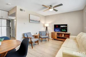 een woonkamer met een bank en een tafel bij Remodeled Apt w Gated Community and In-Unit Laundry in Austin
