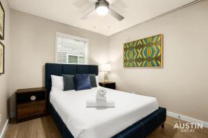 een slaapkamer met een groot wit bed en een plafondventilator bij Remodeled Apt w Gated Community and In-Unit Laundry in Austin