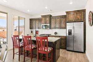 a kitchen with wooden cabinets and a kitchen island with red chairs at Desert Rose home in Washington