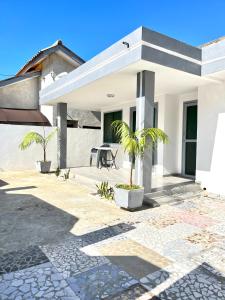 una casa blanca con palmeras en el patio en Villa meublée Cotonou fidjrosse 05 min de la plage, en Cotonou