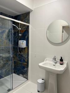 uma casa de banho branca com um lavatório e um chuveiro em Riverfront Apartments at The Blue Goat Ramelton em Ramelton