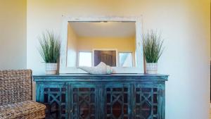a mirror on top of a wooden dresser with two plants at The Beach House townhouse in Washington +33 photos