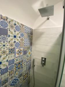 un bagno con piastrelle bianche e blu sul muro di CASA ICARO ad Amalfi