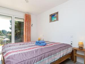 Un dormitorio con una cama con una toalla azul. en Apartment Moré III by Interhome en Llança