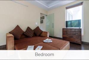 uma sala de estar com uma cama e uma televisão em Luxury 9BHK Villa with Private Pool Near Candolim em Marmagao