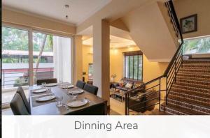 a dining area with a table and chairs and a staircase at Luxury 9BHK Villa with Private Pool Near Candolim in Marmagao