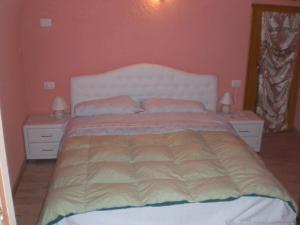 a bedroom with a large bed with two pillows at Casa Domenica in Mezzana