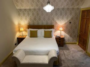 una camera da letto con un grande letto con due comodini e due lampade di The Farmhouse B&B a Dunkeld