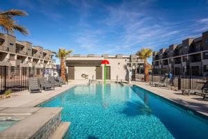 a large swimming pool with chairs and a building at Family Paradise at the Vue #29 townhouse in St. George