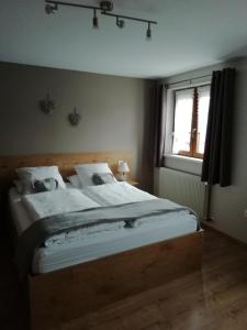 um quarto com uma cama grande e uma janela em Gîte HAURY em Cleebourg