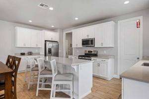a kitchen with white cabinets and a table and chairs at The Bend at Paseos in Washington